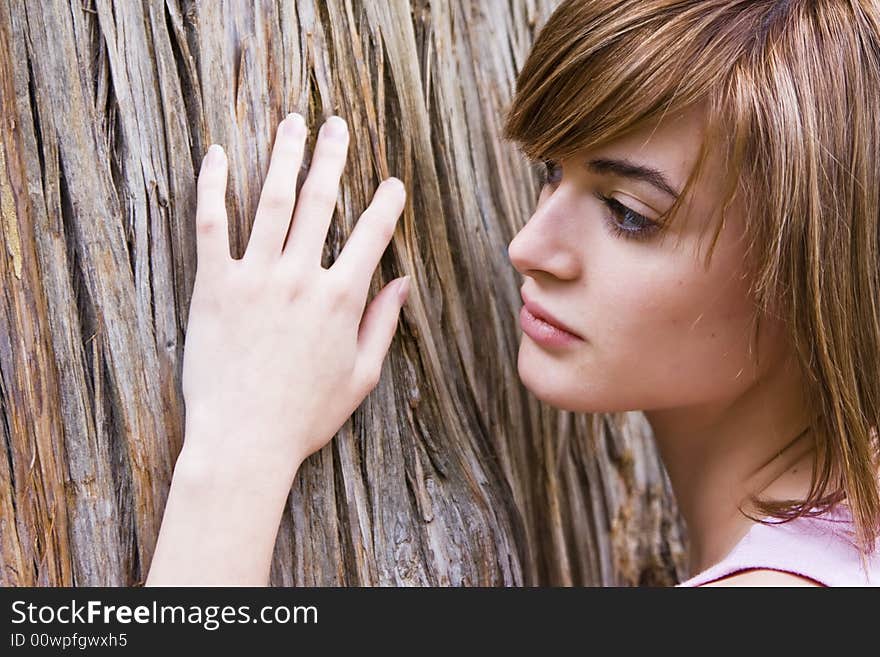 Young woman portrait over a tree trunk