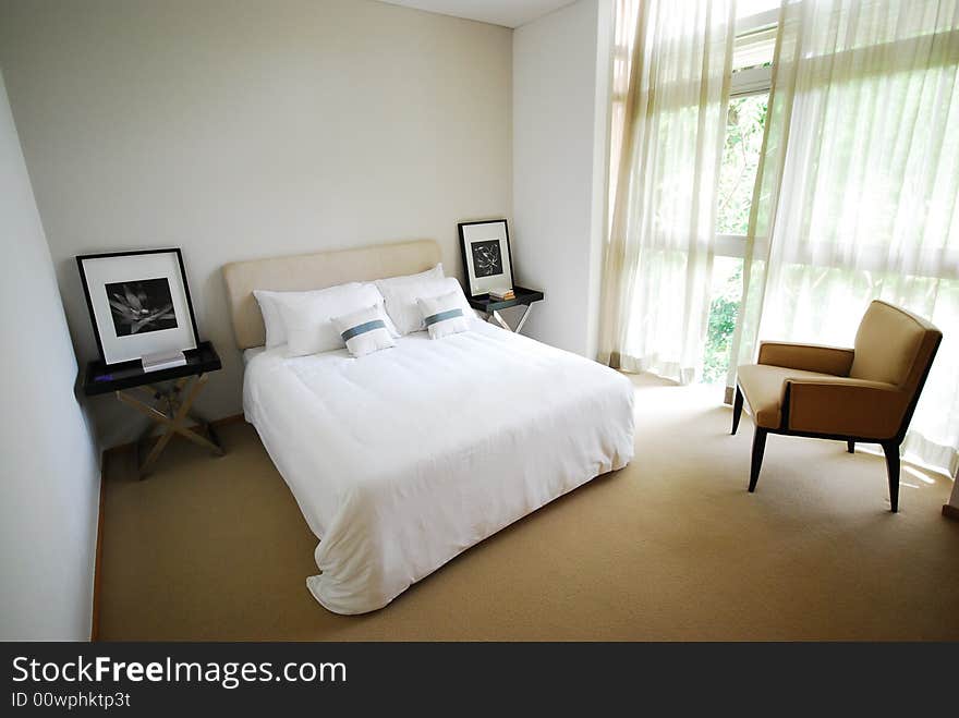 Comfortable bedroom with neatly made white bed. Comfortable bedroom with neatly made white bed.