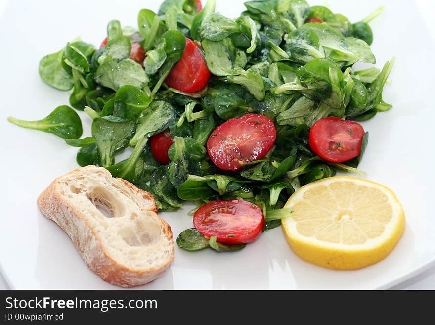 Fresh salad with tomatoes and a piece of bread