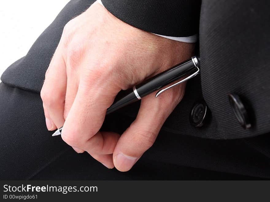 Close up of a person's hand in a black suit holding a pen. Close up of a person's hand in a black suit holding a pen