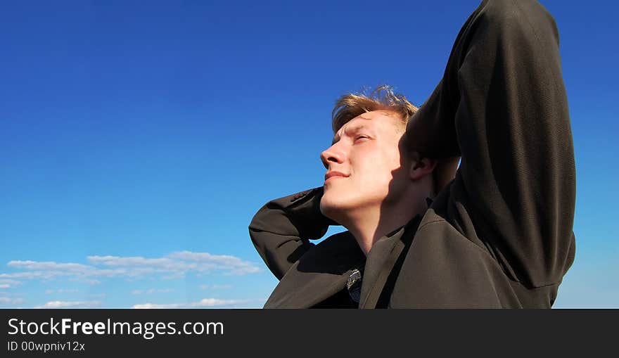 A young man having a rest and looking at clouds. A young man having a rest and looking at clouds