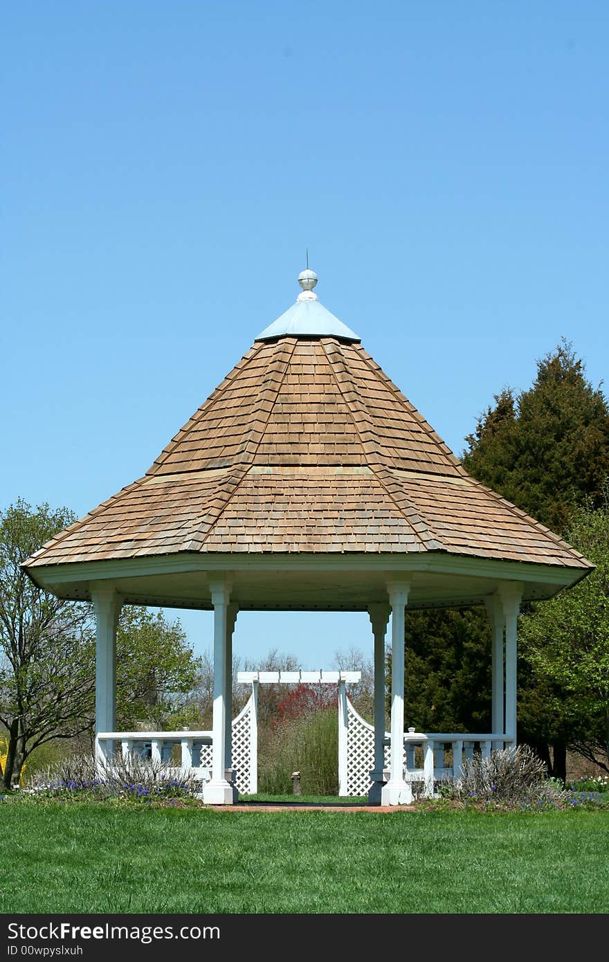 White gazebo in a park with blue sky