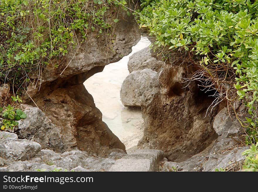 The path to Tautu reef in Niue goes through a natural tunnel in the coral rock.  Stairs have been made in the tunnel to ease the trip down to the reef. The path to Tautu reef in Niue goes through a natural tunnel in the coral rock.  Stairs have been made in the tunnel to ease the trip down to the reef