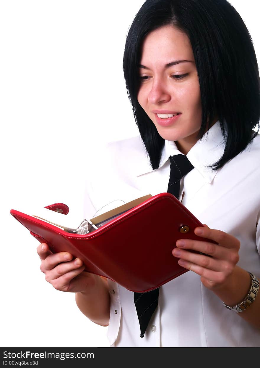 A portrait about a young attractive businesswoman with black hair who is holding a red calendar, she is happy because she got some free days. She is wearing a white shirt and a black tie. A portrait about a young attractive businesswoman with black hair who is holding a red calendar, she is happy because she got some free days. She is wearing a white shirt and a black tie.