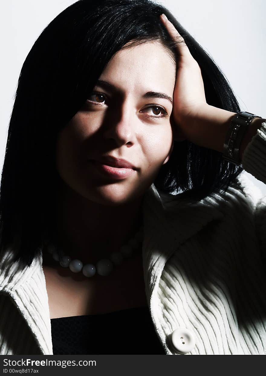 A high-key portrait about an attractive lady with black hair who is looking at something, she is wishing something and she has a charming look. She is wearing a white coat, a black dress and a white necklace. A high-key portrait about an attractive lady with black hair who is looking at something, she is wishing something and she has a charming look. She is wearing a white coat, a black dress and a white necklace.