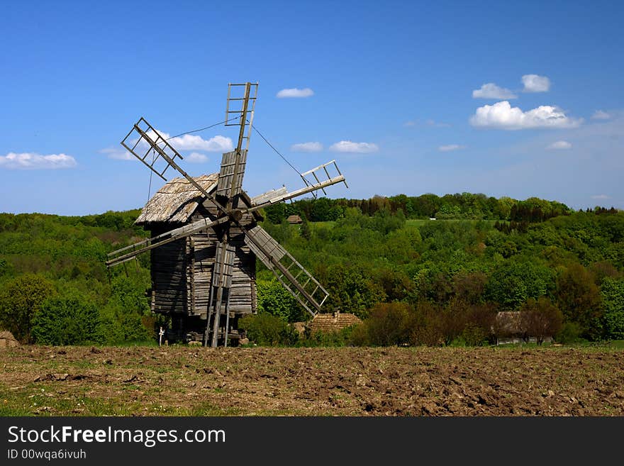 Windmill with fresh green grass and clear blue sky