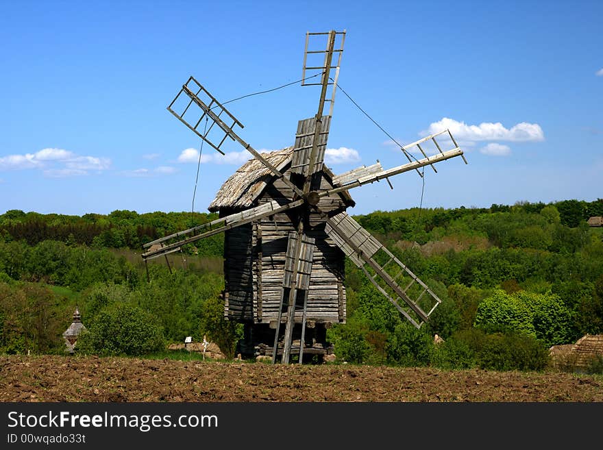 Windmill with fresh green grass and clear blue sky