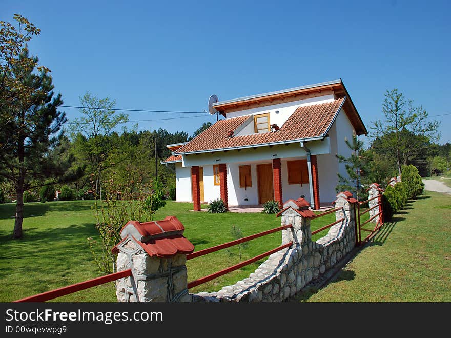 White house with red roof and yard in nature. White house with red roof and yard in nature