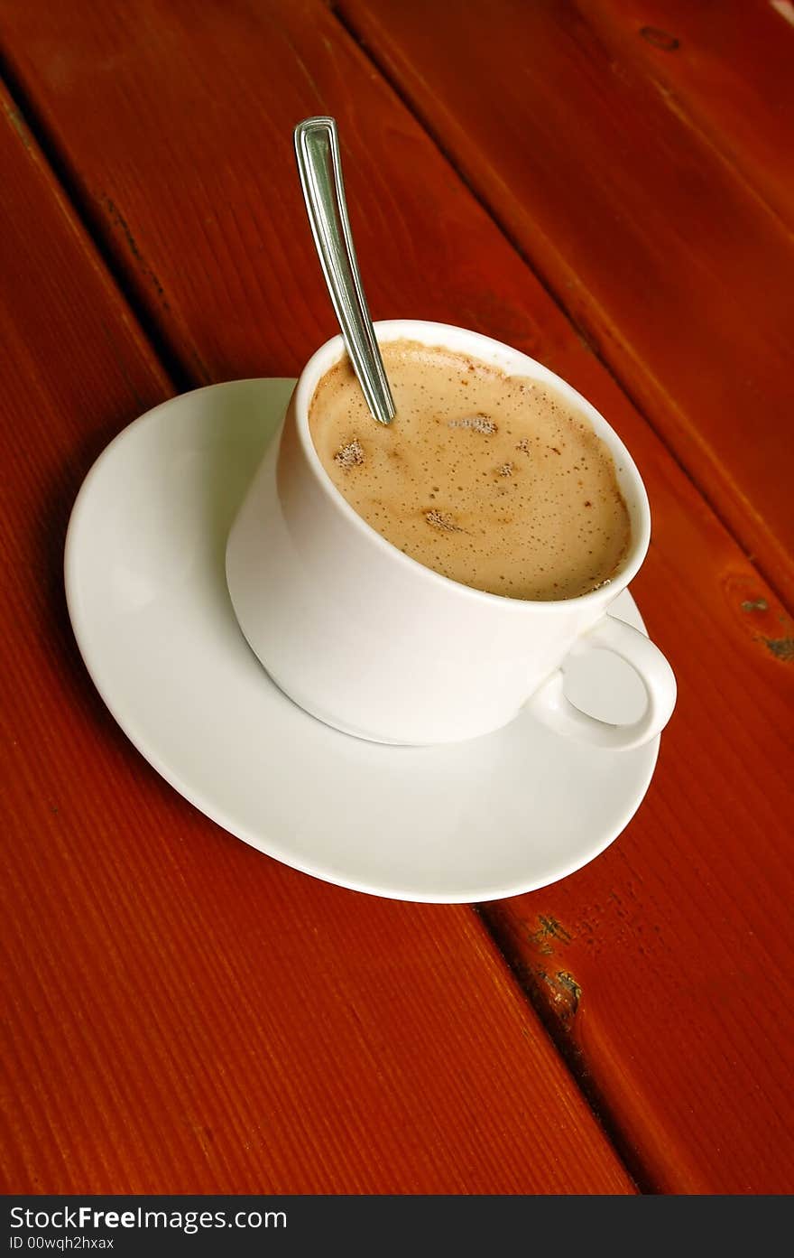 Cappuccino cup with spoon inside