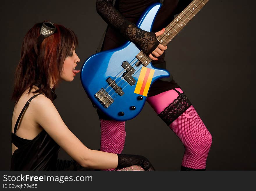 Rock girl licking bass guitar