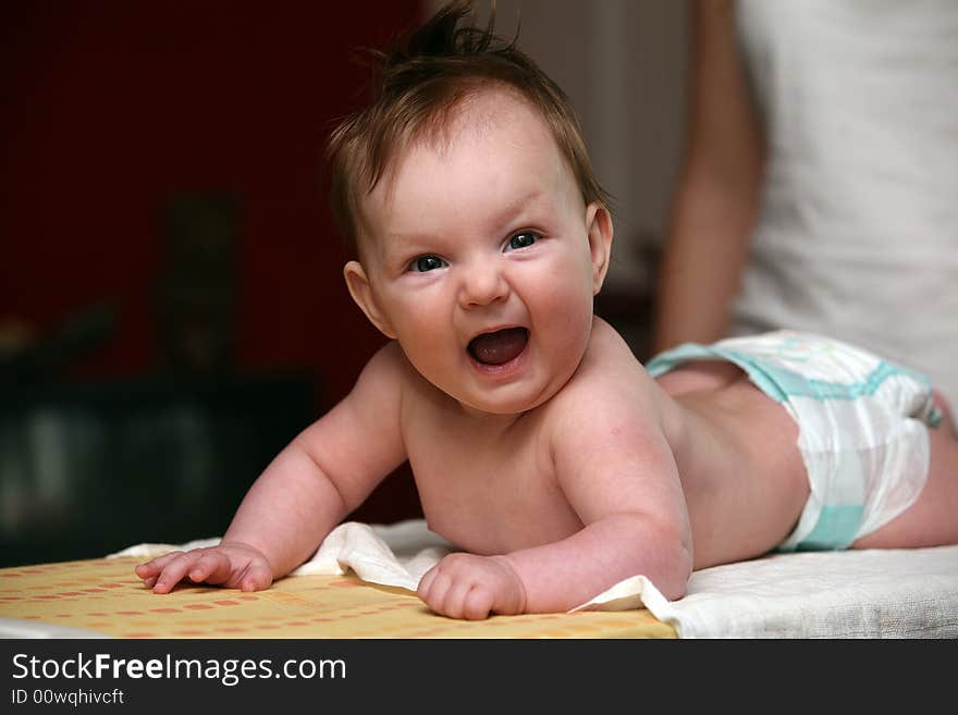 Small baby girl lying prone and smiling