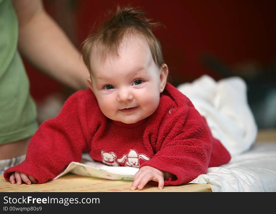 Small baby girl lying prone and smiling