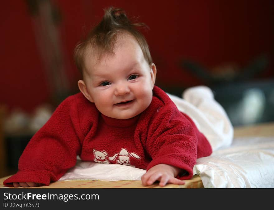 Small baby girl lying prone and smiling