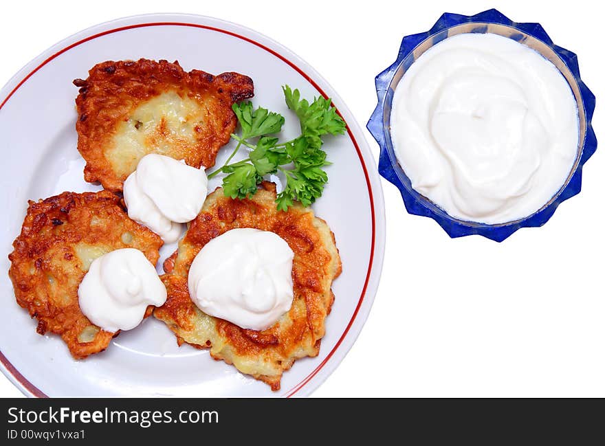 Potato pancakes with sour cream isolated on white