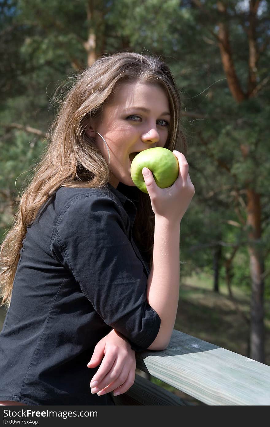 Young girl with apple on forest background