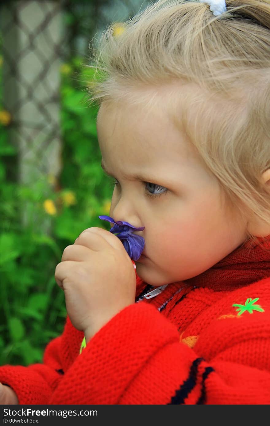 Little girl walks in the spring on a young grass