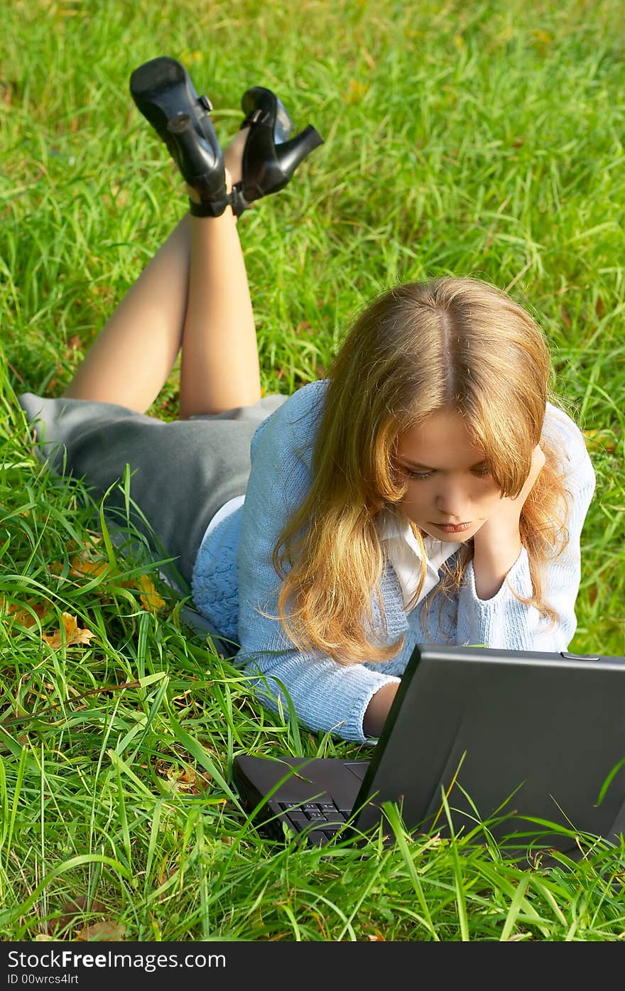 Businesswoman lying on green grass with notebook. Businesswoman lying on green grass with notebook