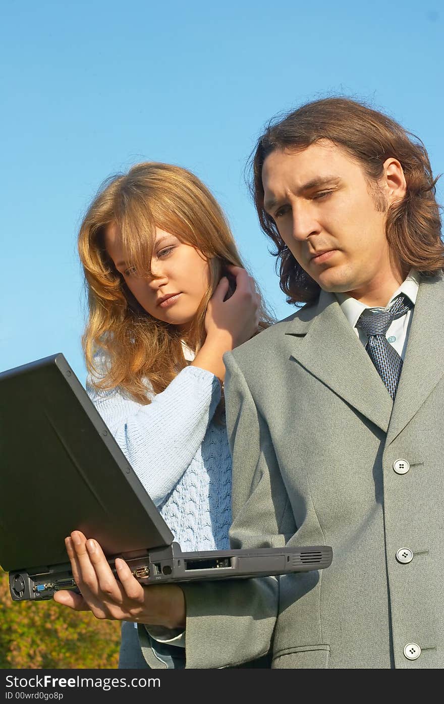 Business couple discussing something with notebook in hands