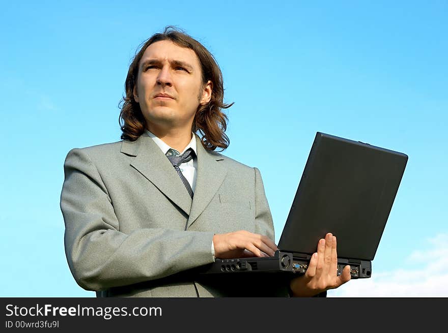 Businessman with notebook under the skies