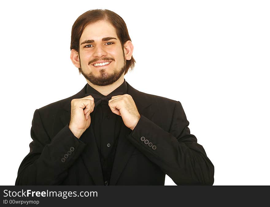 Shot of isolated young man wearing formal suit and bow tie. he is holding his bow tie. Shot of isolated young man wearing formal suit and bow tie. he is holding his bow tie