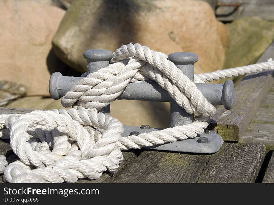 White rope tied to the cleat at the dock. White rope tied to the cleat at the dock