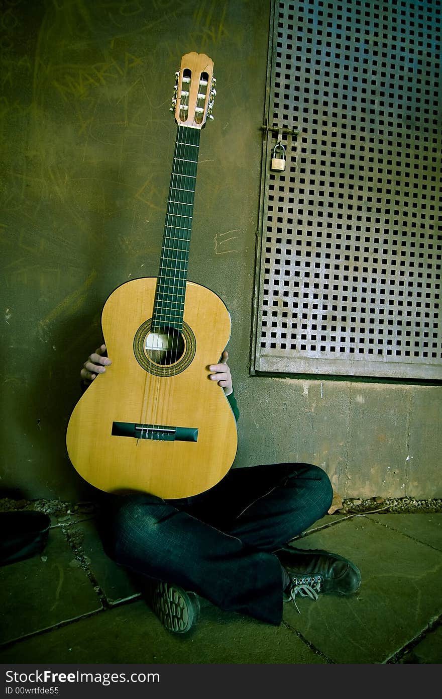 Young guitar performer behind the instrument. Cross processed. Young guitar performer behind the instrument. Cross processed.