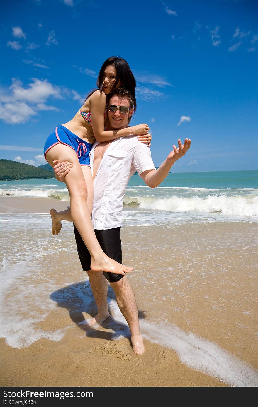 Young couple enjoying themselves on a beautiful day at the beach. Young couple enjoying themselves on a beautiful day at the beach