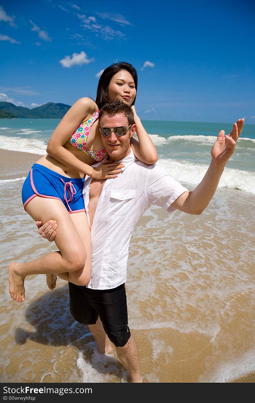 Young multiethnic couple enjoying themselves on a beautiful day at the beach. Young multiethnic couple enjoying themselves on a beautiful day at the beach