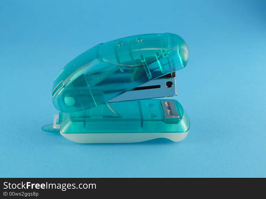 Office stapler on the blue background