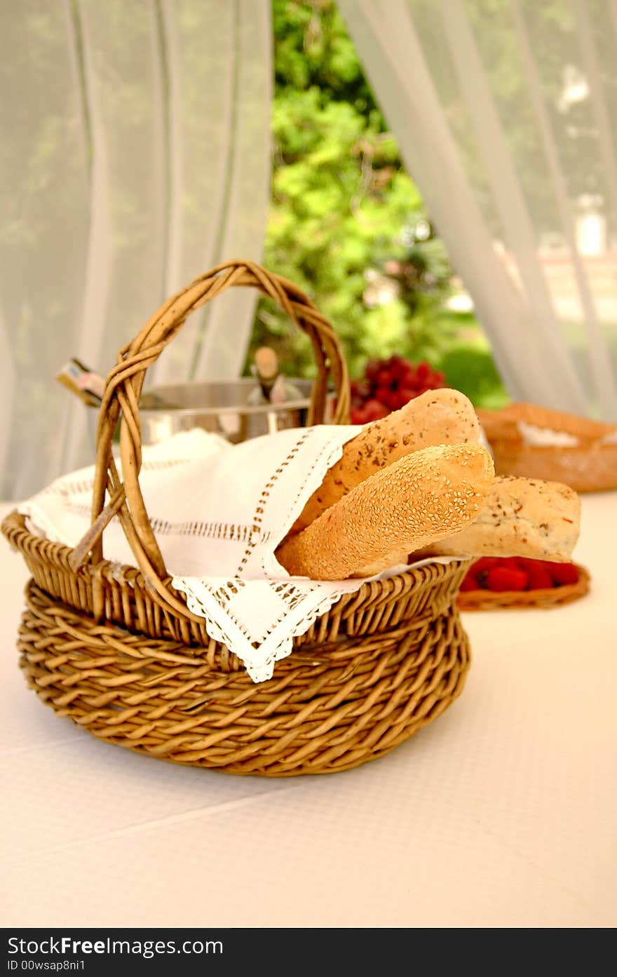 Table setting with bread basket outdoors with wine bottles on background. Table setting with bread basket outdoors with wine bottles on background