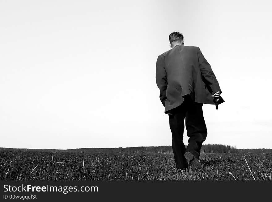 Man with a gun walking across a field. An image inspired by a movie of Quentin Tarantino. Man with a gun walking across a field. An image inspired by a movie of Quentin Tarantino