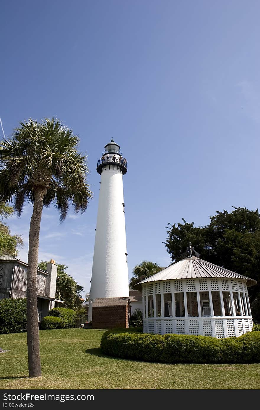 A lighthouse, palm tree, and gazebo on the coast. A lighthouse, palm tree, and gazebo on the coast