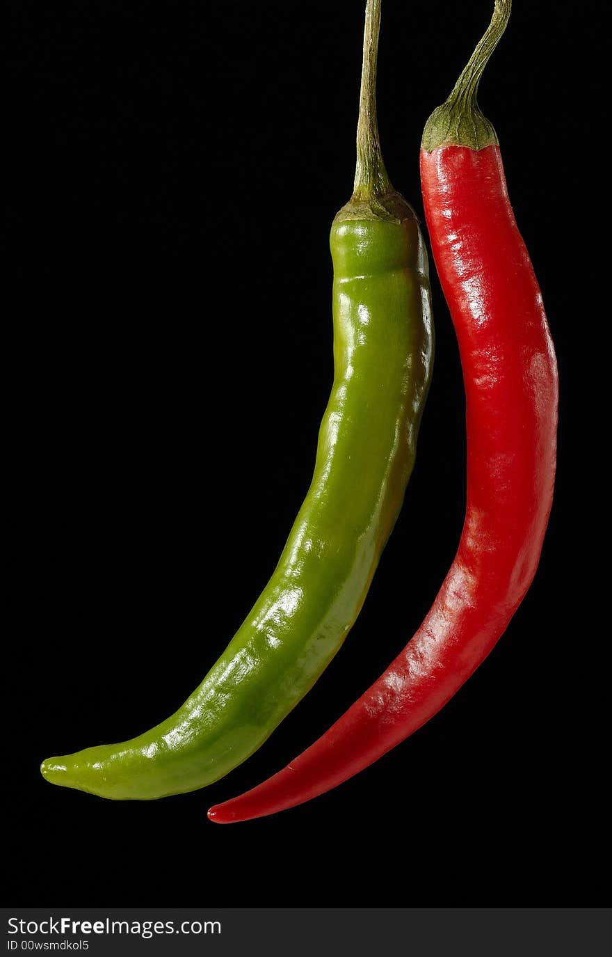 Red and Green Peperoni before black background