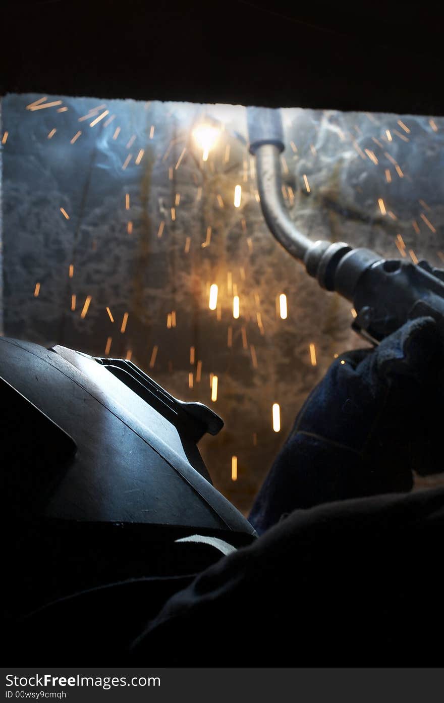 A welder working at shipyard during night shift. A welder working at shipyard during night shift