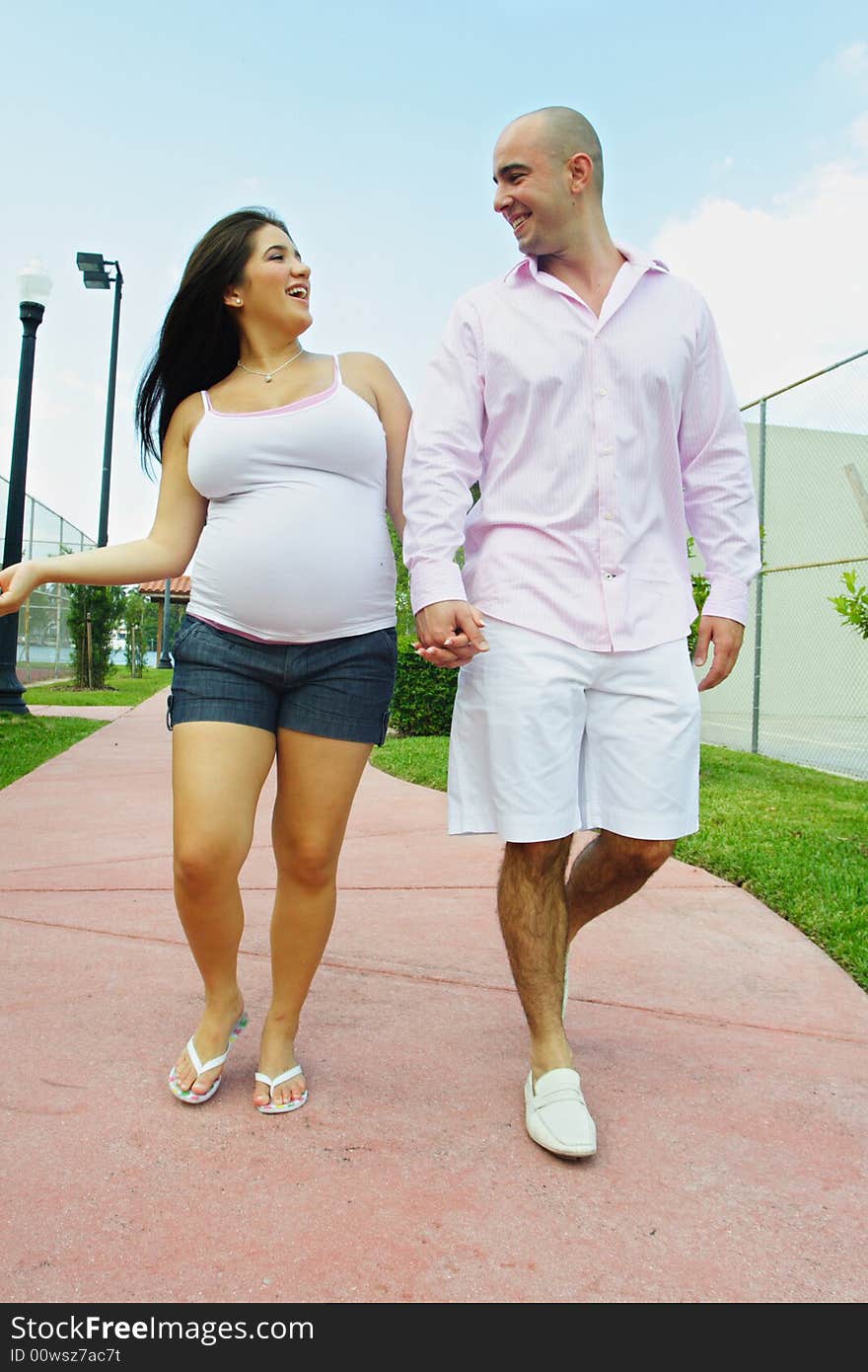 Couple walking on a sidewalk at a park and having happy conversations. Couple walking on a sidewalk at a park and having happy conversations