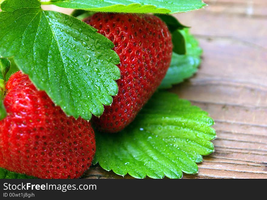 Two Glistining Strawberries On Weathered Wood