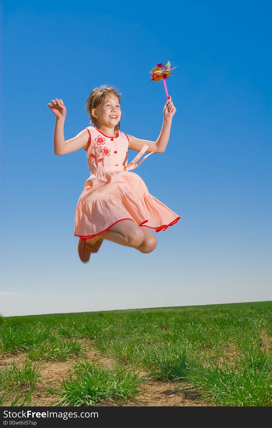 Playful pretty girl, jumping with pinwheel outdoors. Playful pretty girl, jumping with pinwheel outdoors