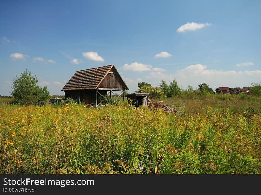 Old house on meadow with blue sky