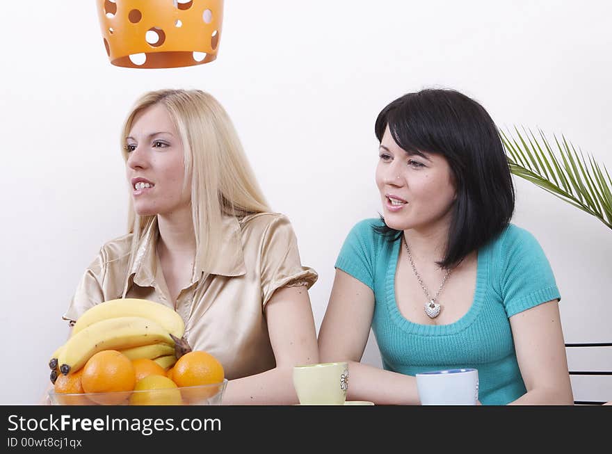 Two girlfriends looking at window and drinking coffee. Two girlfriends looking at window and drinking coffee