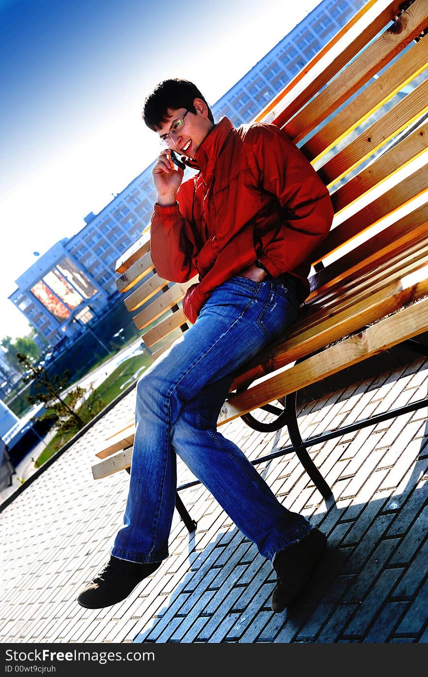 Young student sitting on bench in town