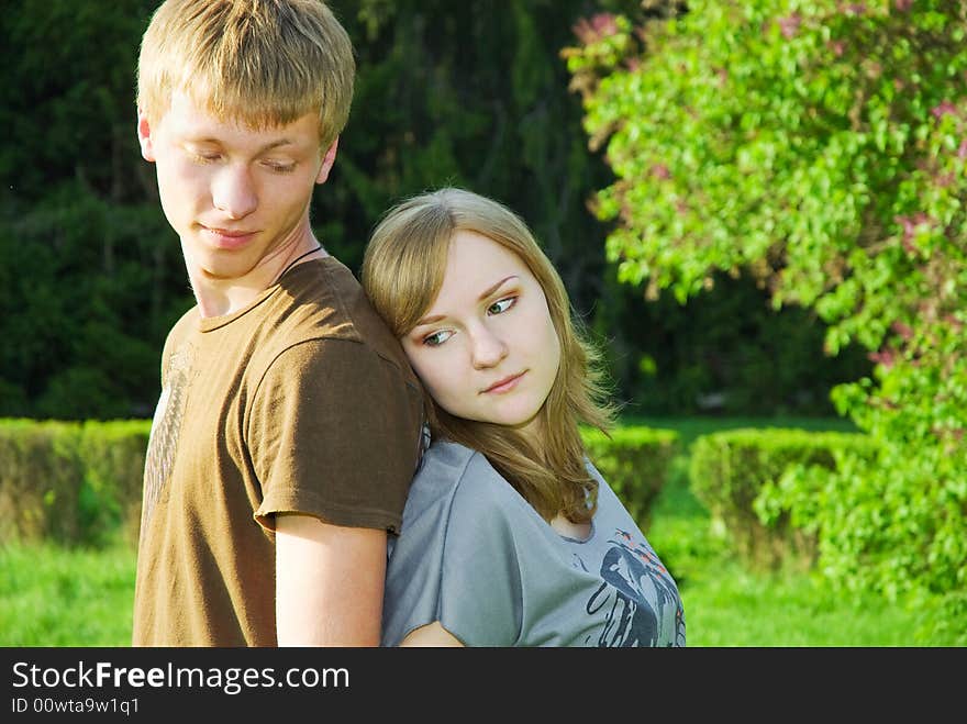 Peaceful couple of young adults outdoors, man attentively shut off his girlfriend from the sun