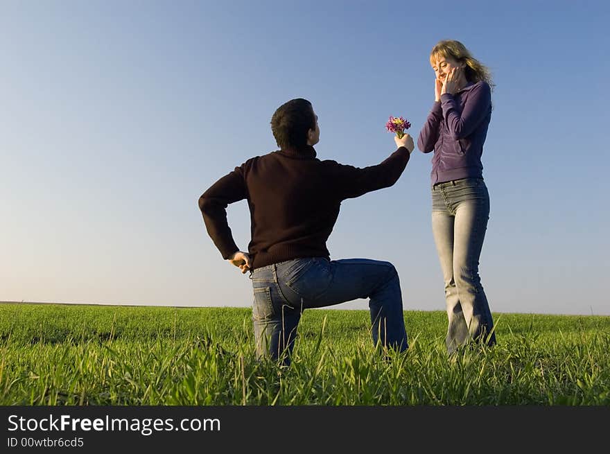 Guy stand on a knee and gives a bouquet to the girl. Guy stand on a knee and gives a bouquet to the girl