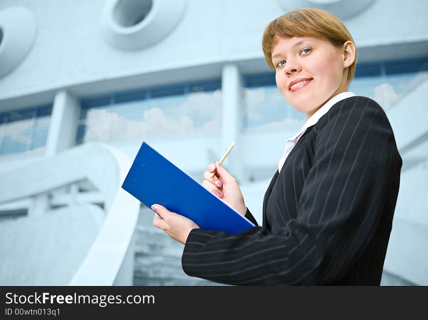 Business woman with folder stand on front building