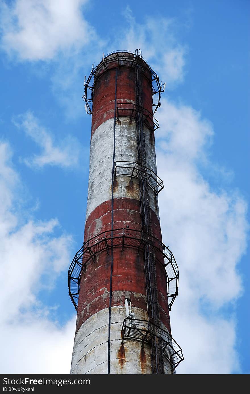 Old factory metallic  funnel on a background sky with clouds