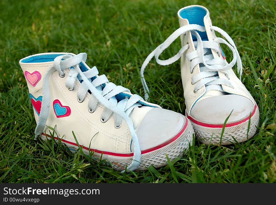 Girl sport shoes in the grass