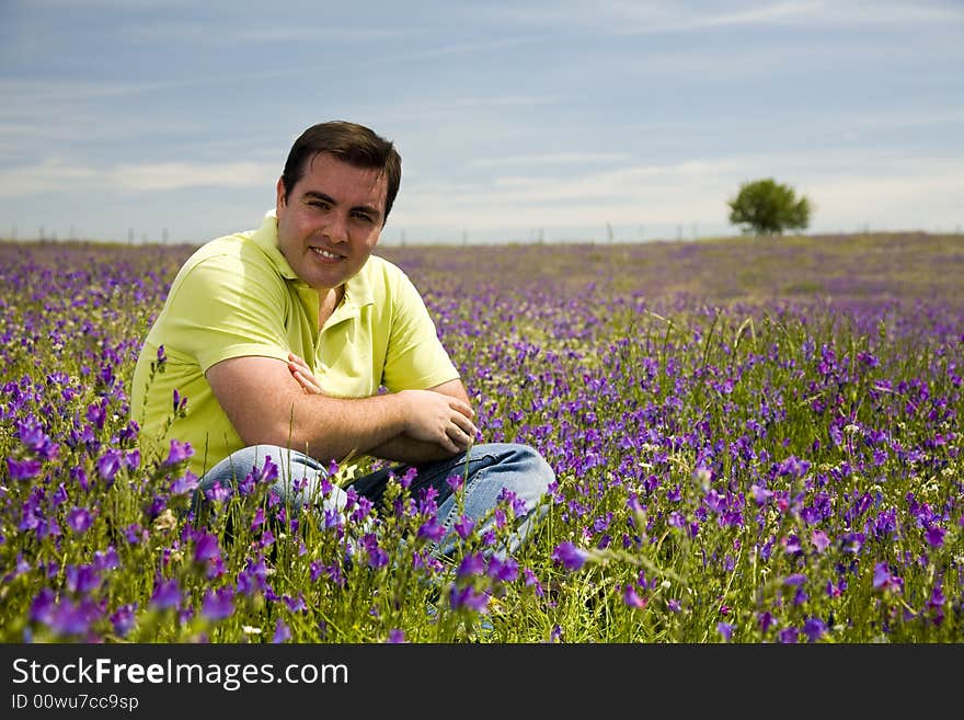 Young man sit in a flower field