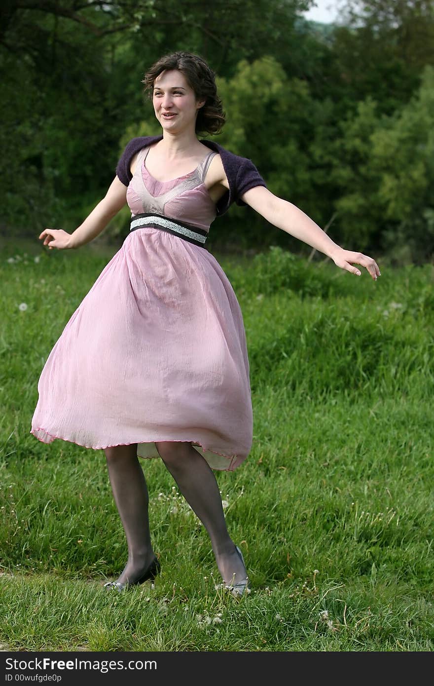 Woman swirling with joy on a green field