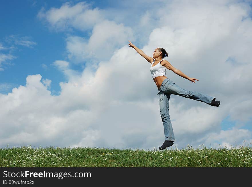 Jumping girl on the green meadow