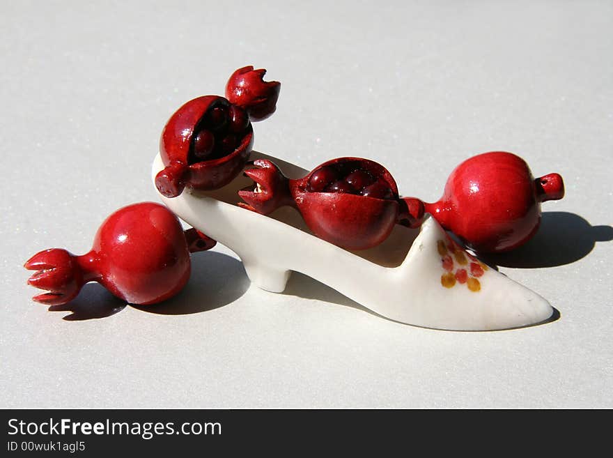 Red fruits of a pomegranate on a stone shoe. Red fruits of a pomegranate on a stone shoe