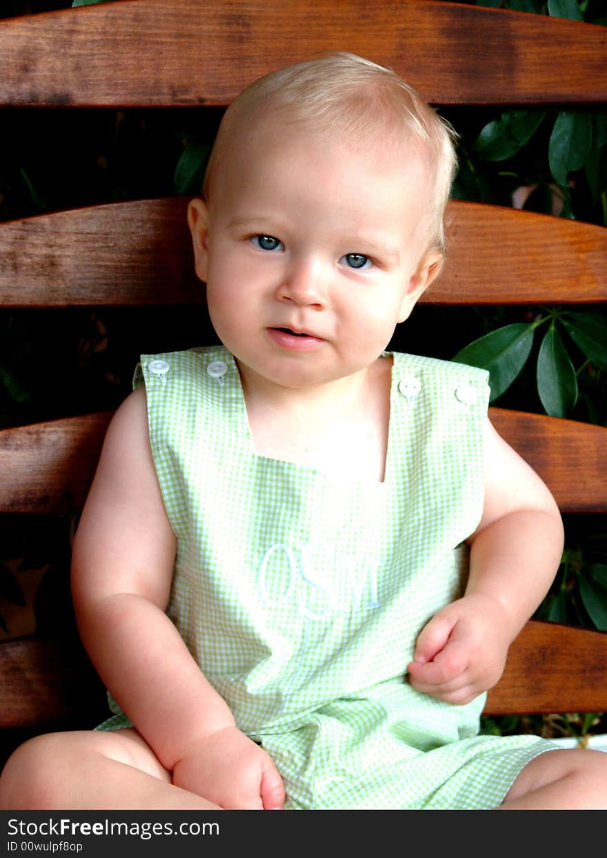 Baby boy on rocking chair on front porch of family home. Baby boy on rocking chair on front porch of family home